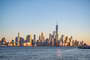 Fototapeta na wymiar New York Skyline Downtown (Financial district) Manhattan in Morning sunrise lights view. Famous location on blue sky background.