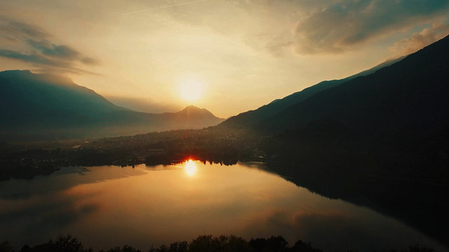 Lake sunset view. magic hour. golden dusk sky. aerial view. Levico Italy