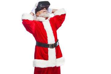 Christmas. Santa Claus in black virtual reality glasses makes gestures with his hands. Surprise, emotion. New technology. Isolated on white background.