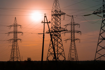 Energy sector of the country. High-voltage poles-support in the light of the rays of the setting sun