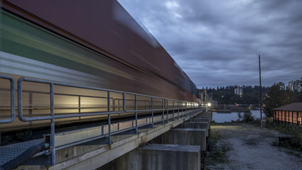 Obraz premium Patullo Bridge, Surrey, British Columbia, Canada. Long exposure of the bridge over the water. Sky Train Bridge.
