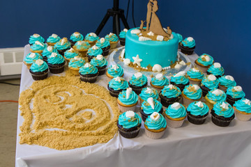 Wedding cake with cupcakes, brown sugar sand, closeup, nobody.