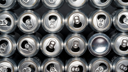 Stack of empty aluminum beer cans, front side view, close up, macro with one can being backwards. Be different from your herd.