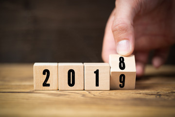 Hand dreht Würfel und symbolisiert Jahreswechsel zwischen 2018 und 2019