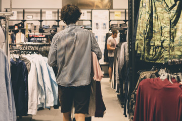 young male teenager walking in the casual clothes store shopping concept