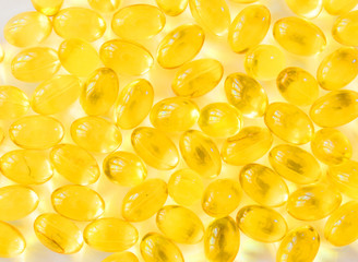 Fish oil capsules on wooden background, vitamin D supplement, selective focus, copy space for text.