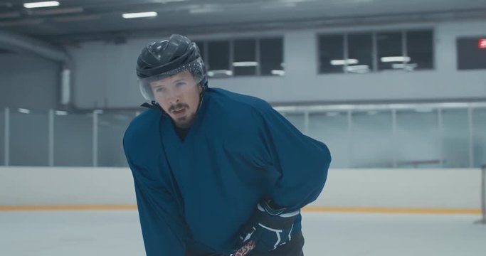 Caucasian male ice hockey player catching breath during practice at the training arena. 4K UHD