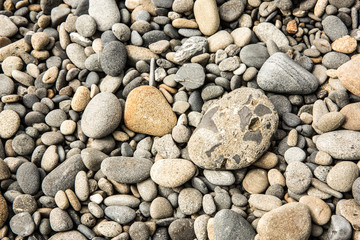 Piece of concrete tumbled in the pacific ocean on a natural pebble beach