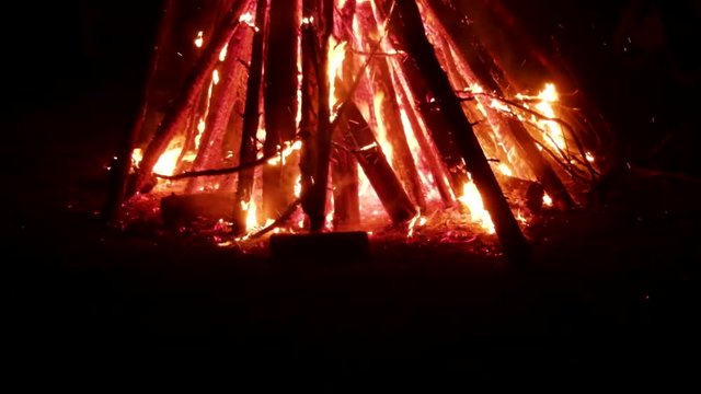 Huge fire at night and young people around. Pagan festival of Walpurgis night: bonfires, dancing wildly, demons, witches. Folk festival, popular holiday. German legends, St. Walburgas and Satanism
