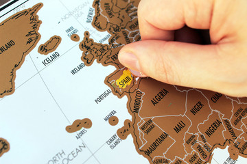 Fototapeta premium Man's hand scratching of visited places on a map. Europe travel. A travel destinations concept
