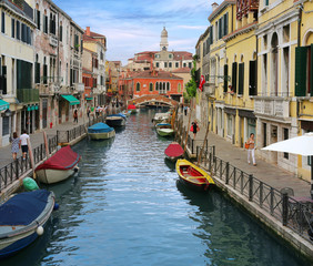 Fototapeta na wymiar Charming Venetian canal street with colorful boats
