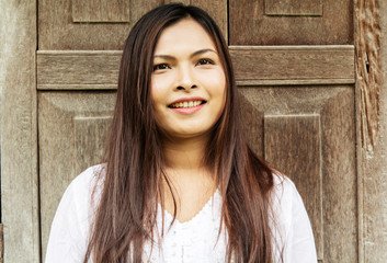 Woman with smile and old wooden wall