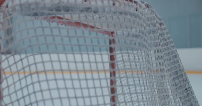 CU Ice hockey puck hits the net. 4K UHD 60 FPS SLOW MOTION