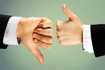 Human hands showing agree sign Versus disagree on background