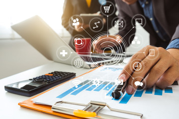 Working team meeting concept, businessman using smart phone and laptop and digital tablet computer with virtual interface icons network diagram office in morning light