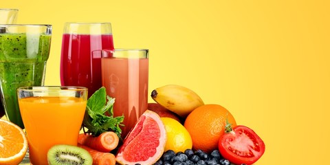 Fototapeta na wymiar Fresh ripe healthy fruits and juices in glasses