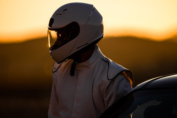 Ein behelmter Fahrer, der sich auf ein Rennen bei Sonnenaufgang vorbereitet