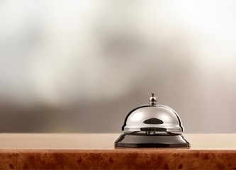 Vintage hotel reception service desk bell on blurred background