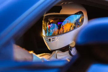 Stof per meter Een gehelmde bestuurder aan het stuur van zijn raceauto © SIX60SIX