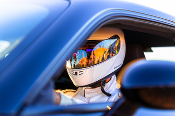 A Helmeted Driver At The Wheel Of His Race Car