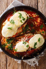 Delicious chicken Sorrentino breast with aubergines, ham, cheese and marinara sauce close-up on a plate. Vertical top view