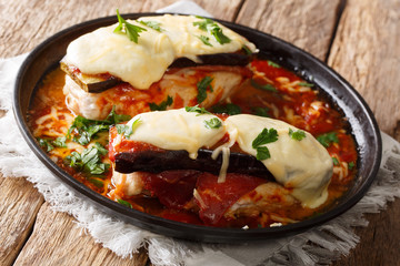 Tender chicken breasts topped with eggplant slices, prosciutto, marinara sauce, mozzarella, and Parmesan close-up on a plate. horizontal 