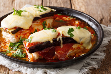 Delicious chicken Sorrentino breast with aubergines, ham, cheese and marinara sauce close-up on a plate. horizontal
