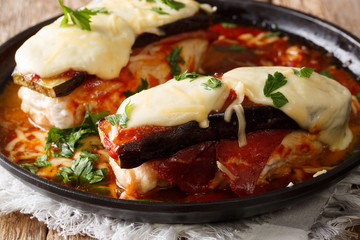 Recipe Italian Sorrentino chicken with eggplants, ham, cheese and marinara sauce close-up on a plate on a table. horizontal