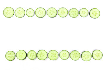 Cucumber slices forming a frame on a white background with copyspace