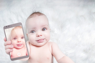 Funny baby girl taking selfie with tongue out