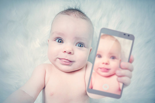 Funny baby girl taking selfie with tongue out