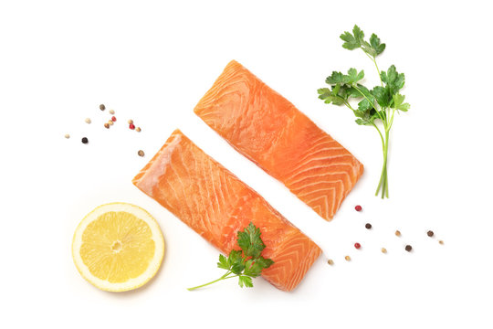 Slices of salmon with lemon, parsley, and pepper, on a white background with copy space, overhead photo