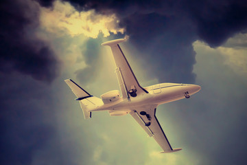 An airplane flying through a dramatic raincloud sky