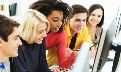 Group of Students with computer at lesson in classroom