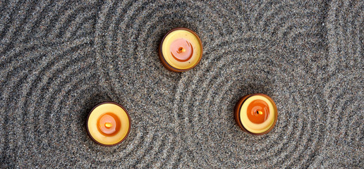 Zen composition. Candles in the sand. Calming patterns on the sand.