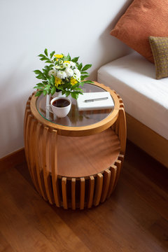 Bedroom Interior. Nightstand With Flowers And A Cup Of Coffee On It.