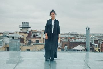 girl in black clothes standing on the edge of the roof