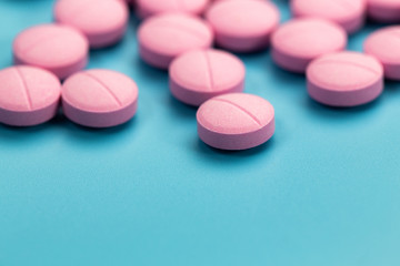 Obraz na płótnie Canvas pink pills on blue background