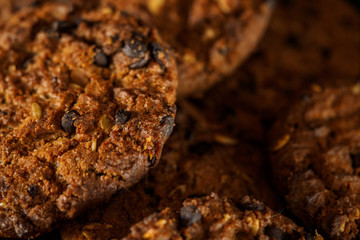 Chocolate chip cookies on rustic dark black background. Stacked 