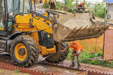 Driver at the construction site washes the excavator on the overpass