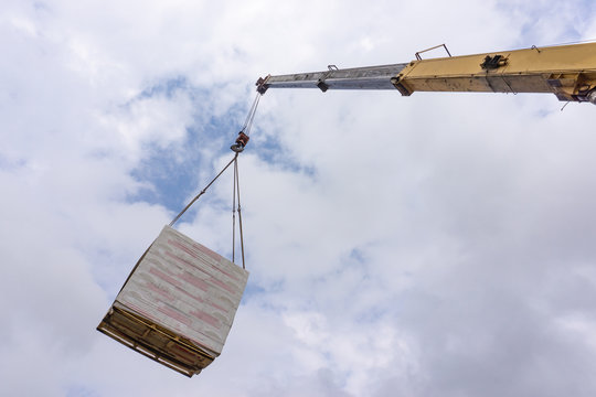 Unloading of building materials by crane at the construction site