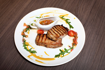 grilled meat with rosemary on wooden background.