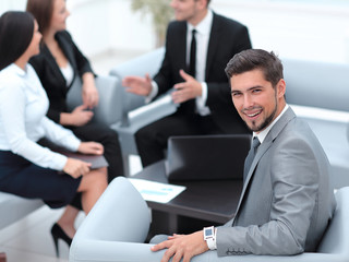 businessman sitting in an office on the background of business team.