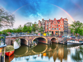 Obraz premium Kanał Amsterdamski z typowymi holenderskimi domami i tęczą, Holandia, Holandia.