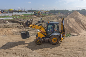 Tractor carries a concrete ring for a well
