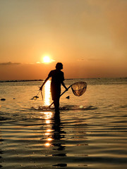 Fisherman silhouette at sunset sunrise