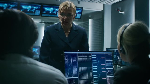 Female Chief Operative Officer talks to Cyber Security Dispatchers Working on Personal Computer Showing Traffic Data Flow in the System Control Room.