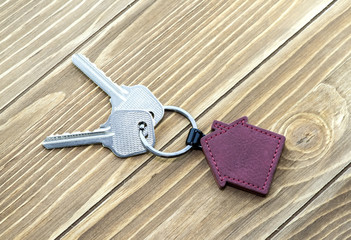 keychain with house symbol and keys on wooden background,Real estate concept
