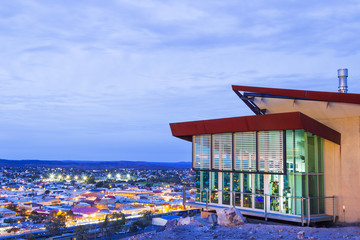 Broken Hill city skyline at twilight. Aerial view from a lookout with blue sky and lit buildings.
