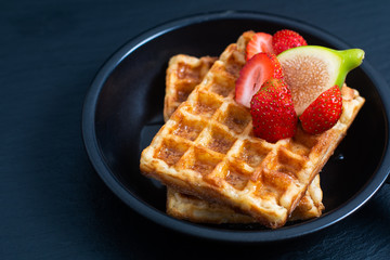 Food concept square Waffles and syrup with strawberry and fig topping in iron pan with copy space